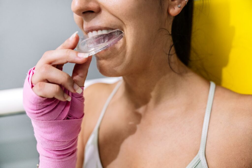 adult woman inserting clear mouth guard