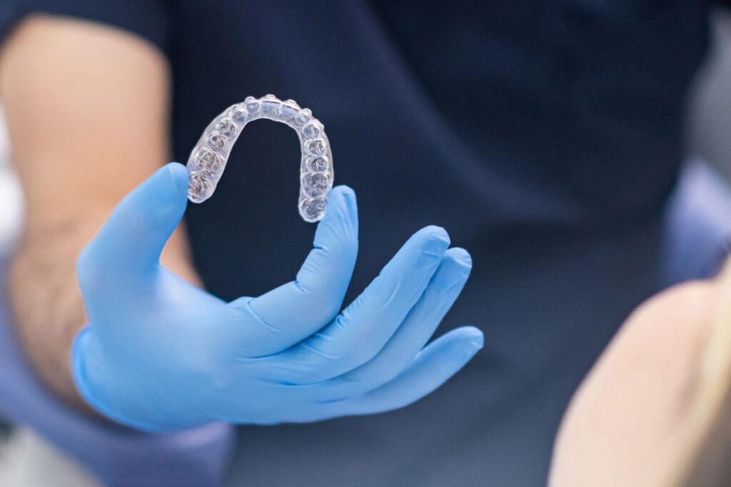dental professional holding clear teeth alignment