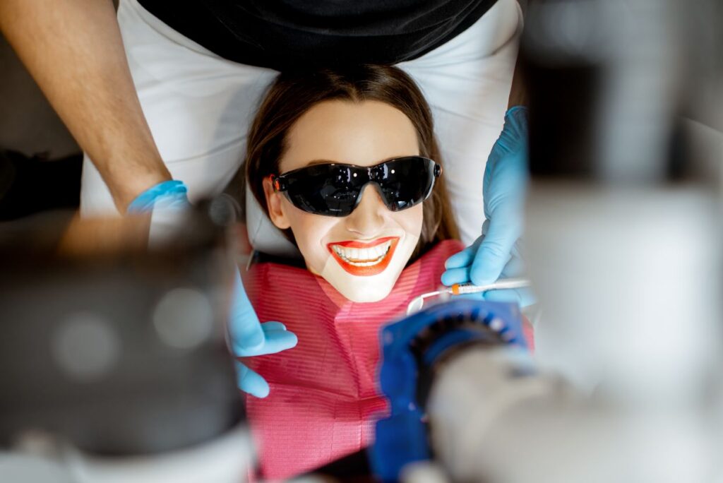 smiling woman in a dentist chair with goggles