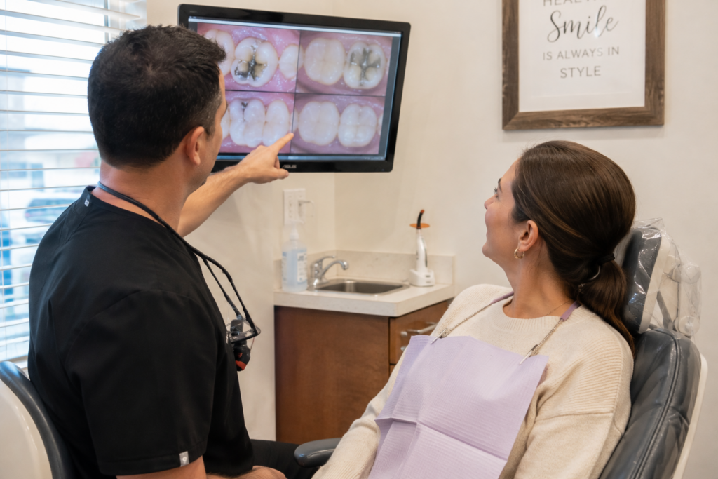 Dentist reviewing older dental work with a patient during a routine dental evaluation.
